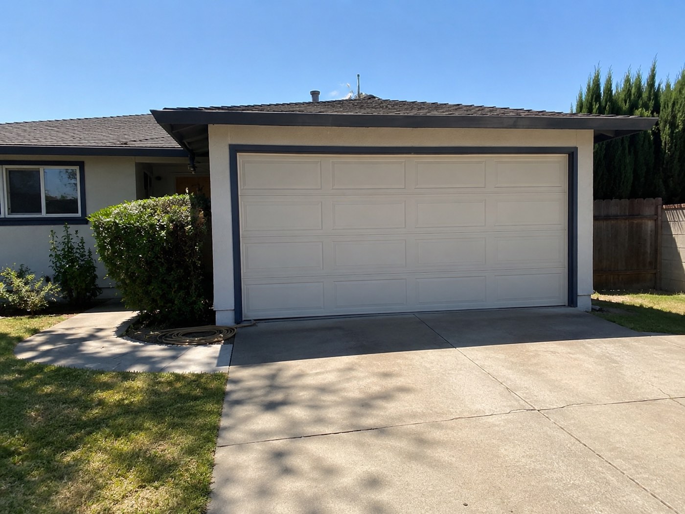 Classic single-story La Habra ranch home with a two-car garage door — the kind still running its original torsion springs