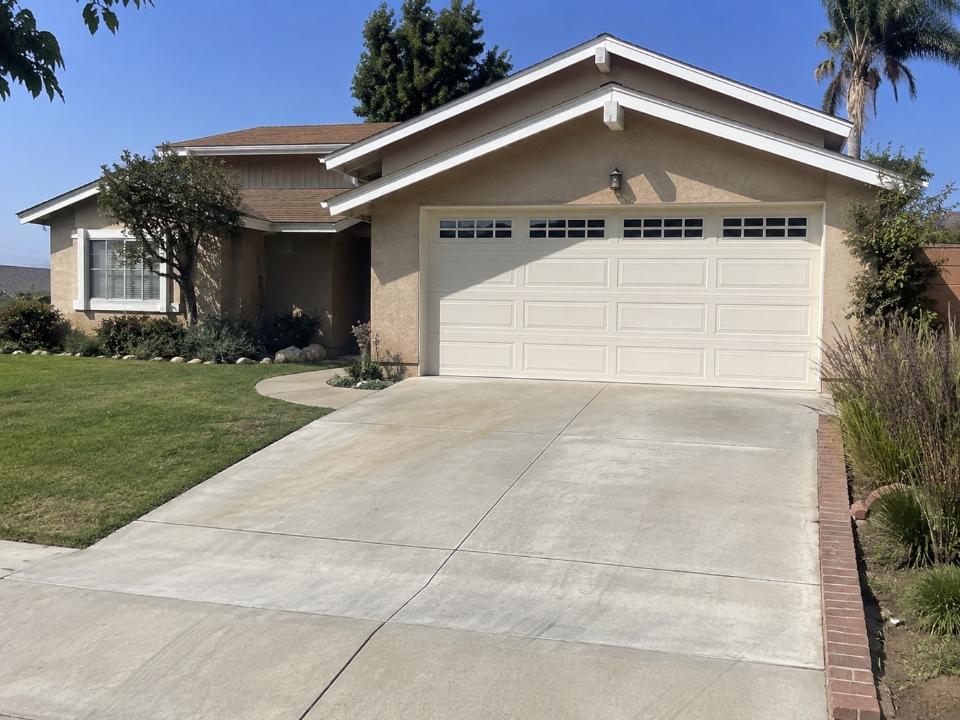 Single-story La Habra ranch home with a cream carriage-window two-car garage door